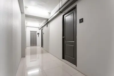 a hallway with a black door and white walls at LKN RESIDENCE in Pom Prap