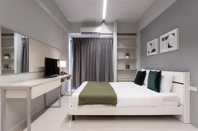 a bedroom with a bed and a desk and a television at LKN RESIDENCE in Pom Prap