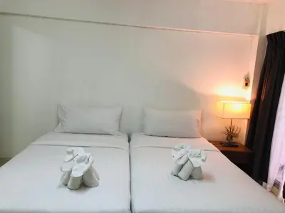 two stuffed animals sitting on top of two beds at I-Inn Hotel in Bangkok