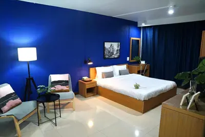 a bedroom with a bed and a blue wall at The View Residence in Bangkok