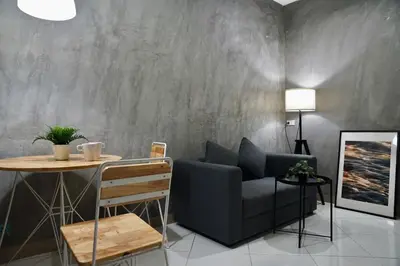 a living room with a chair and a table at The View Residence in Bangkok