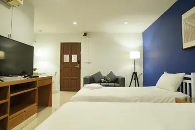a hotel room with two beds and a flat screen tv at The View Residence in Bangkok