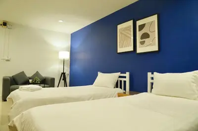two beds in a room with a blue wall at The View Residence in Bangkok
