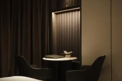 a room with two chairs and a table with a book at Cascade Hotel Bangkok in Bangkok