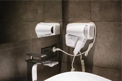 a bathroom with a hair dryer and a blow dryer at Cascade Hotel Bangkok in Bangkok