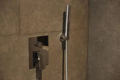 a shower in a bathroom with a toilet paper holder at Cascade Hotel Bangkok in Bangkok