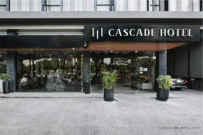 a hotel with potted plants in front of a building at Cascade Hotel Bangkok in Bangkok