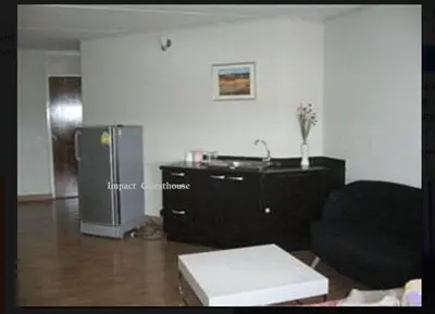 a living room with a couch and a refrigerator at Chan Kim Don Mueang Guest House in Thung Si Kan