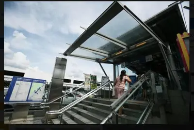 a woman standing on the stairs at a bus stop at Chan Kim Don Mueang Guest House in Thung Si Kan