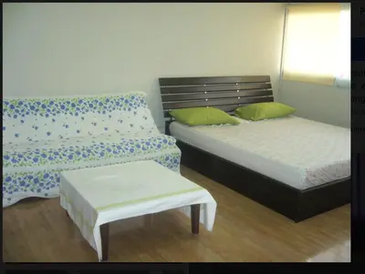 a bedroom with two beds and a bench and a table at Impact -Challenger Muang thong Thani in Thung Si Kan