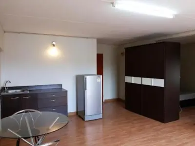 a kitchen with a stainless steel refrigerator and a table at Asia Don Mueang Bangkok Condominium in Thung Si Kan
