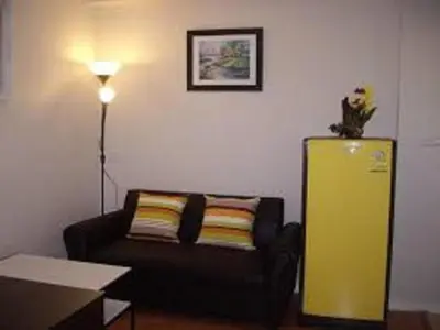 a living room with a couch and a yellow refrigerator at Asia Don Mueang Bangkok Condominium in Thung Si Kan