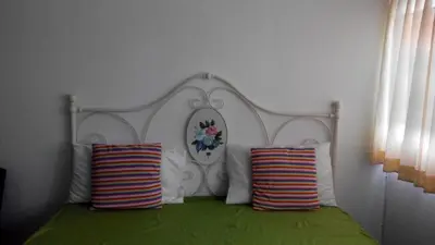 a bed with a white headboard and two pillows at Asia Don Mueang Bangkok Condominium in Thung Si Kan