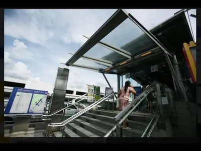 a woman walking up the stairs at a bus stop at Impact Don Mueang Bangkok Guest House in Thung Si Kan