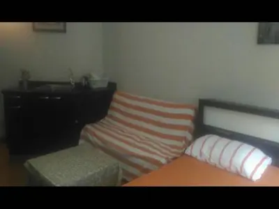a room with a bed and a bench and a desk at Impact Don Mueang Bangkok Guest House in Thung Si Kan