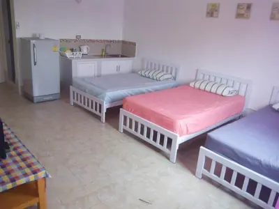 a room with three beds and a kitchen with a refrigerator at Impact Thunder Dome Service Taxi in Thung Si Kan