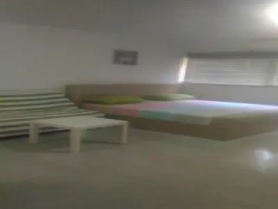 a bedroom with two beds and a couch and a table at T8 Guest House Don Mueang Challenger triple room in Ban Song Hong