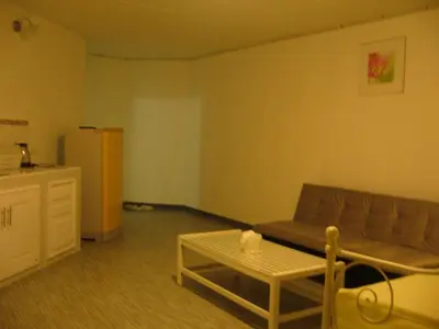 a living room with a couch and a table at Chan Kim Don Mueang Guest House Triple room in Thung Si Kan