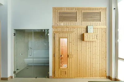 a wooden door in a bathroom with a toilet at W1Bangkoknoi Hotel in Nonthaburi
