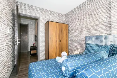 a bedroom with two beds next to a brick wall at The Base Park East - Bangkok Sukhumvit 77 in Bangkok