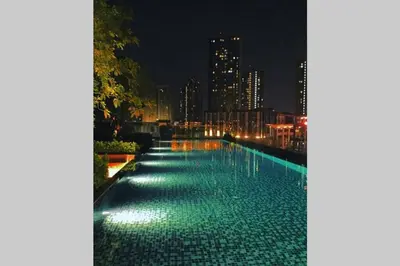 a swimming pool with green lights at night at The Base Park East - Bangkok Sukhumvit 77 in Bangkok