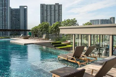a swimming pool with lounge chairs on top of a building at The Base Park East - Bangkok Sukhumvit 77 in Bangkok
