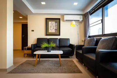 a living room with a couch and a table at Anandpura Riverside Hotel in Bangkok