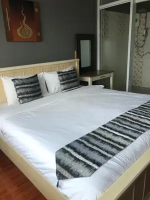 a large bed with black and white pillows on it at Anandpura Riverside Hotel in Bangkok
