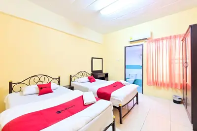 two beds with red pillows in a room at Big Bird Palace Ladprao 71 in Bangkok