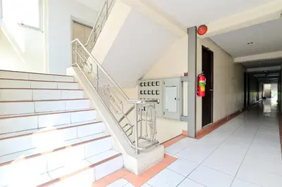 a staircase in a building with a red light at Big Bird Palace Ladprao 71 in Bangkok