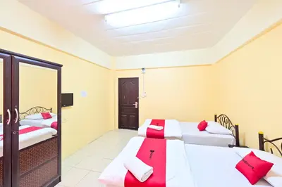 a room with two beds and a mirror at Big Bird Palace Ladprao 71 in Bangkok