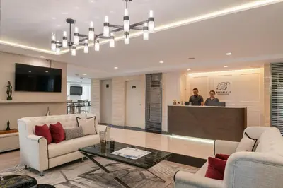 a living room with two people standing in a kitchen at Beverly 33 by Aspira in Bangkok