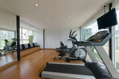 a gym with treadmills and cardio machines in a room at Beverly 33 by Aspira in Bangkok