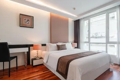 a bedroom with a large bed and a large window at Beverly 33 by Aspira in Bangkok