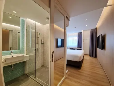 a bathroom with a bed and a sink and a shower at Mintel Huamark in Bangkok