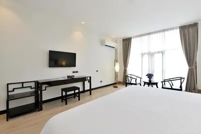 a bedroom with a bed and a desk and a television at Oldthaiheng Hotel in Bangkok