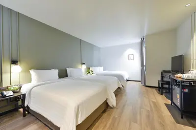 a hotel room with two beds and a television at Oldthaiheng Hotel in Bangkok