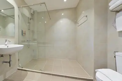 a bathroom with a shower and a sink at Oldthaiheng Hotel in Bangkok