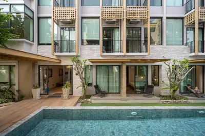 an apartment building with a pool in front of it at SHAN Villas Sukhumvit ฌานวิลล่า สุขุมวิท in Bangkok