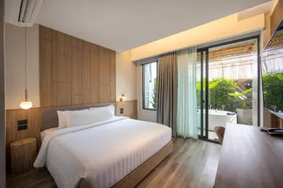 a bedroom with a bed and a bathroom with a tub at SHAN Villas Sukhumvit ฌานวิลล่า สุขุมวิท in Bangkok