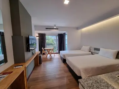 a hotel room with two beds and a flat screen tv at The Key Point Hotel in Bangkok