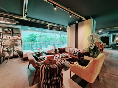 a living room with a couch and a table and chairs at The Key Point Hotel in Bangkok