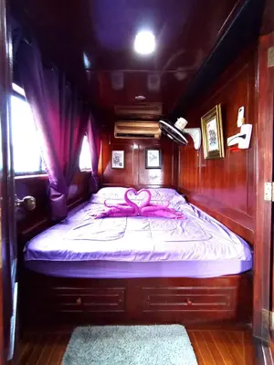 a bed in a boat with a pink bow on it at Sabai Sabai Liveaboard Bangkok in Bangkok