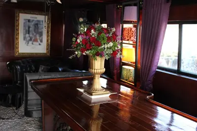 a vase with flowers on a table in a room at Sabai Sabai Liveaboard Bangkok in Bangkok