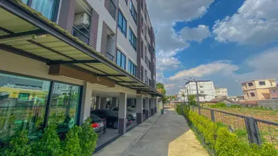a building with a car parked next to a sidewalk at Plearnwan Deluxe Mansion in Bangkok