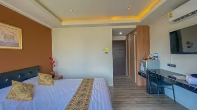a bedroom with a bed and a desk and a kitchen at Plearnwan Deluxe Mansion in Bangkok