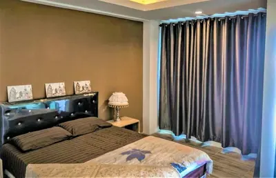 a bedroom with a bed and a large window at Plearnwan Deluxe Mansion in Bangkok