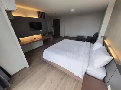 a bedroom with a white bed and a desk at โรงแรมดับเบิ้ลดี ปากเกร็ด Double D hotel in Pak Kret