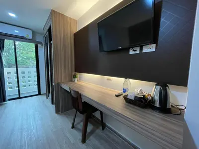a room with a desk with a television on the wall at โรงแรมดับเบิ้ลดี ปากเกร็ด Double D hotel in Pak Kret