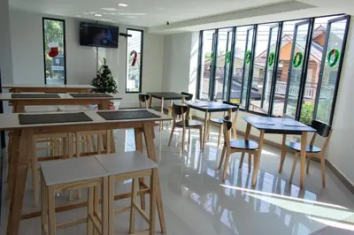 a restaurant with tables and chairs and windows at โรงแรมดับเบิ้ลดี ปากเกร็ด Double D hotel in Pak Kret